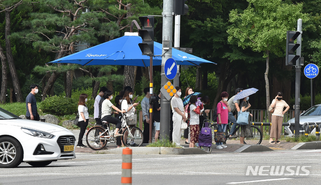 [안산=뉴시스] 김종택기자 = 폭염이 기승을 부린 지난 20일 오후 경기 안산시 단원구 고잔동 거리에서 시민들이 그늘막 아래 모여 신호를 기다리고 있다. 2020.08.20. semail3778@naver.com