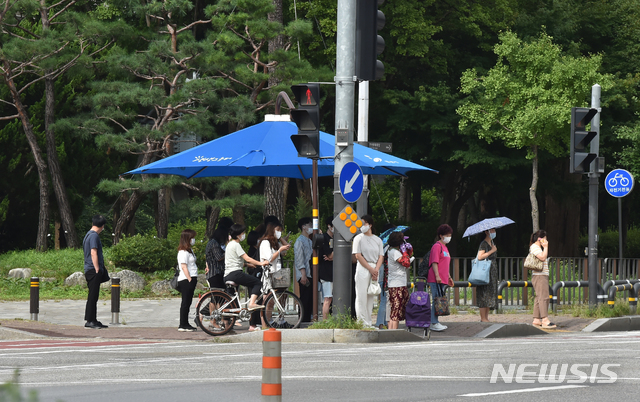 [안산=뉴시스] 김종택기자 = 폭염이 기승을 부린 지난 20일 오후 경기 안산시 단원구 고잔동 거리에서 시민들이 그늘막 아래 모여 신호를 기다리고 있다. 2020.08.20. semail3778@naver.com