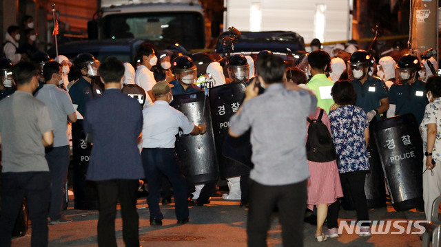 [서울=뉴시스]전진환 기자 = 20일 오후 서울 성북구 사랑제일교회 앞에서 흰색 방역복을 입은 역학 조사관들이 코로나19 역학조사를 위해 경찰의 보호를 받으며 교회로 들어가고 있다. 2020.08.20. amin2@newsis.com