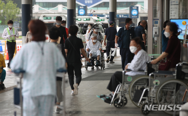 [서울=뉴시스] 조수정 기자 = 정부가 추진하는 의과대학 정원 증원 정책 등에 반대하는 의료계가 집단행동에 돌입, 종합병원 수련 전공의부터 순차 휴진에 들어간 21일 서울 종로구 연건동 서울대학교병원에서 환자들이 출입문 앞에 앉아 있다. 대한의사협회는 이날 오후 3시 용산 임시회관에서 긴급 기자회견을 열고 대국민 담화를 발표할 예정이라고 밝혔다. 2020.08.21. chocrystal@newsis.com