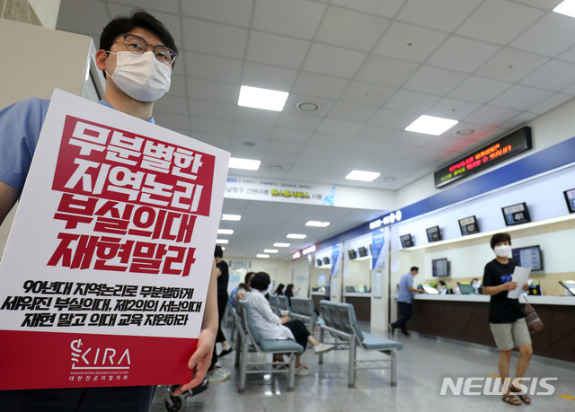 [전주=뉴시스] 김얼 기자 = 전공의들이 무기한 파업에 돌입한 21일 전북 전주시 전북대학교병원 본관에서 한 전공의가 피켓을 들고 시위를 하고 있다. 2020.08.21.  pmkeul@newsis.com