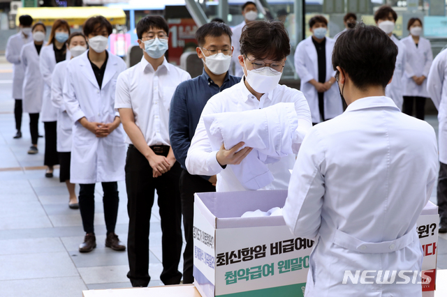 [서울=뉴시스] 이윤청 기자 = 대한전공의협의회 주도 '젊은의사 단체행동' 관계자들이 지난 23일 서울 광진구 건국대병원에서 의대 정원 확대 재논의 등을 촉구하며 의사 가운을 벗고 있다. 2020.08.23. radiohead@newsis.com