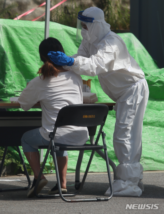 [강릉=뉴시스] 김경목 기자 = 23일 오후 강릉시 보건소 공무원이 강원 강릉시 내곡동 보건소 선별진료소에서 신종 코로나바이러스 감염증(코로나19) 유증상자의 몸에서 검체를 채취하고 있다. 2020.08.23. photo31＠newsis.com