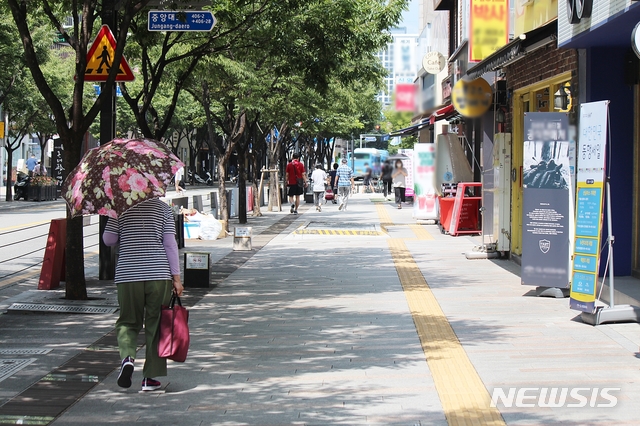 [대구=뉴시스]이지연 기자 = 25일 오후 대구 중구 동성로에 한 시민이 양산을 쓰고 힘겹게 걸어가고 있다. 2020.08.25. ljy@newsis.com