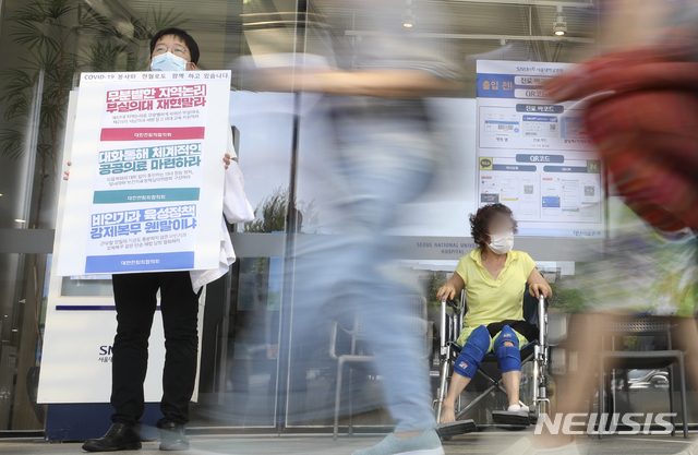 [서울=뉴시스] 최진석 기자 = 대한의사협회 2차 총파업을 하루 앞둔 25일 오전 서울 종로구 서울대학교병원 본관 앞에서 서울대병원 전임의가 정부 의료정책에 반대하는 피켓을 들고 있다. 2020.08.25. myjs@newsis.com