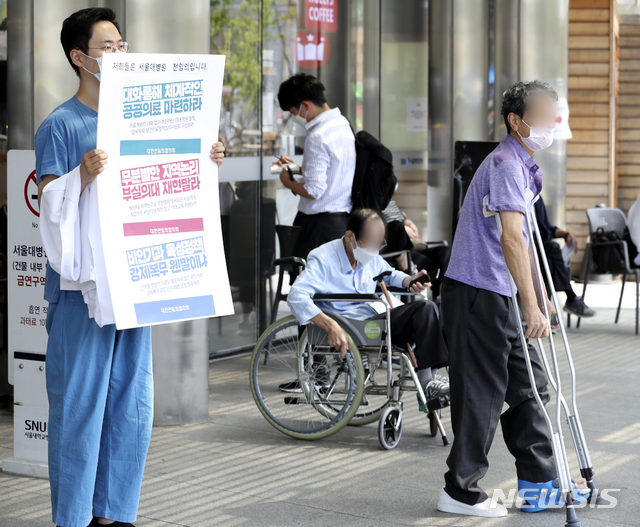 [서울=뉴시스] 최진석 기자 = 대한의사협회 2차 총파업을 하루 앞둔 25일 오전 서울 종로구 서울대학교병원 본관 앞에서 서울대병원 전임의가 정부 의료정책에 반대하는 피켓을 들고 있다. 2020.08.25. myjs@newsis.com