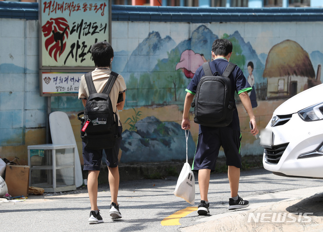 [서울=뉴시스] 고승민 기자 = 교육부가 오는 26일부터 서울 등 수도권 유치원, 초중고(고3 제외) 학교의 등교를 약 3주간 중단하고 원격수업으로 전환한다고 발표한 25일 서울의 한 골목에서 중학생들이 하교를 하고 있다. 교육부는 안정적인 원격수업을 위한 인프라와 원격수업 학습콘텐츠 지원을 강화한다. 2020.08.25.kkssmm99@newsis.com