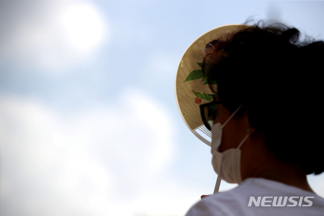 [서울=뉴시스] 박미소 기자 = 전국 대부분 폭염특보가 발효된 지난해 8월25일 오후 서울 종로구 광화문 광장에서 한 시민이 부채로 햇볕을 가리고 있다.2020.08.25. misocamera@newsis.com