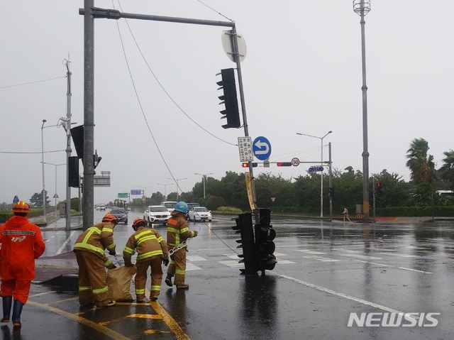 [제주=뉴시스] 강경태 기자 = 제8호 태풍 ‘바비’의 강풍으로 26일 오전 제주시 연동 마리나호텔 사거리에서 신호등이 도로에 쓰러져 출동한 소방대원들이 안전조치를 하고 있다. (사진=독자 제공) 2020.08.26. ktk2807@newsis.com