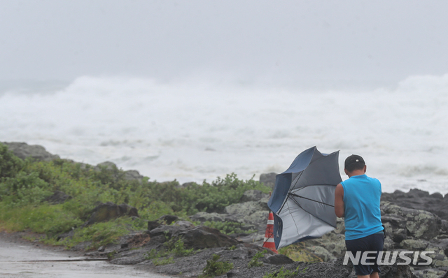 [서귀포=뉴시스]우장호 기자 = 제8호 태풍 '바비'(BAVI)가 우리나라를 향해 북상 중인 26일 오전 제주 서귀포시 안덕면 대평리 인근 해안가에 한 주민이 힘겹게 걸어가고 있다. 2020.08.26. woo1223@newsis.com
