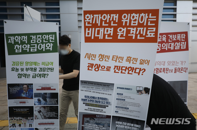 [서울=뉴시스] 고승민 기자 = 정부가 의과대학 정원 확대 등을 반대하며 집단휴진(총파업)에 나선 전공, 전임의에게 업무개시명령을 내린 26일 서울의료원에서 전공의들이 정부정책을 반대하는 입간판을 설치하고 있다. 2020.08.26. kkssmm99@newsis.com