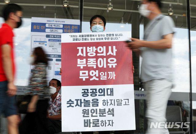 [서울=뉴시스]홍효식 기자 = 정부가 의과대학 정원 확대 등을 반대하며 집단휴진(총파업)에 나선 전공, 전임의에게 업무개시명령을 내린 26일 오전 서울 종로구 서울대병원 로비 앞에서 한 전임의가 피켓 시위를 하고 있다. 2020.08.26.  yesphoto@newsis.com