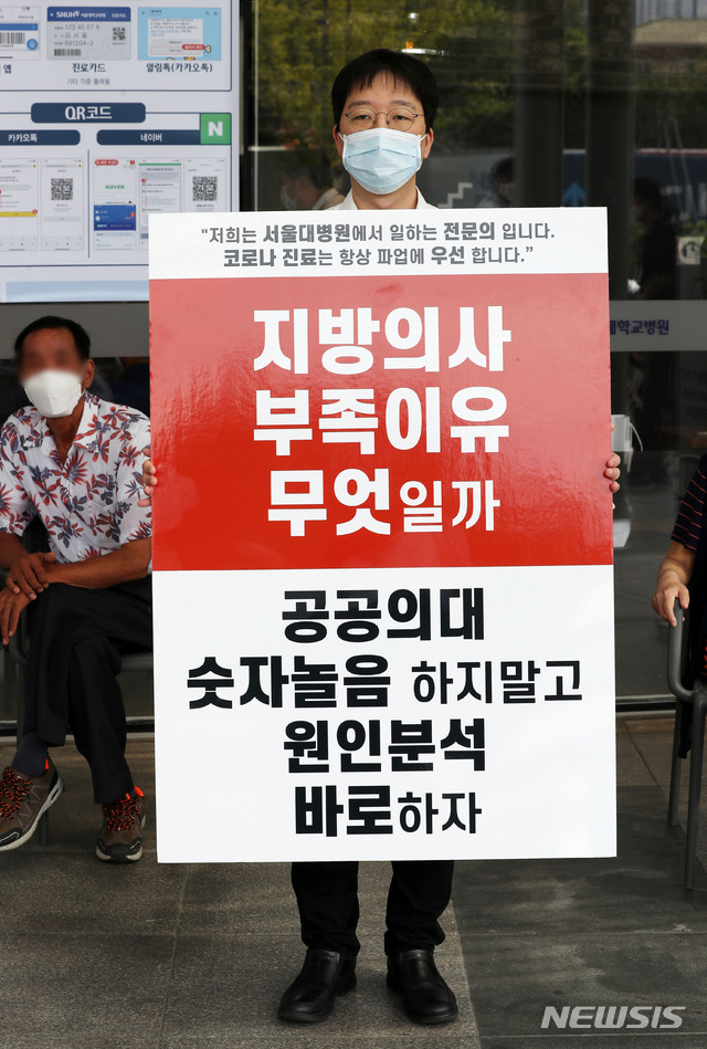 [서울=뉴시스]홍효식 기자 = 정부가 의과대학 정원 확대 등을 반대하며 집단휴진(총파업)에 나선 전공, 전임의에게 업무개시명령을 내린 26일 오전 서울 종로구 서울대병원 로비 앞에서 한 전임의가 피켓 시위를 하고 있다. 2020.08.26.&nbsp; yesphoto@newsis.com