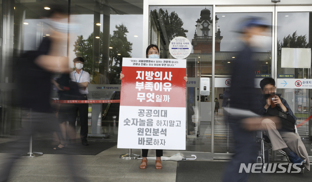 [서울=뉴시스] 최진석 기자 = 의과대학 정원 증원 등 정부 정책 철회를 요구하는 대한의사협회(의협)의 2차 총파업이 이틀째 이어지고 27일 오전 서울 종로구 서울대학교병원에서 한 전문의가 의과대학 정원확대 등 정부의 의료정책을 반대하는 손팻말을 들고 있다. 2020.08.27. myjs@newsis.com