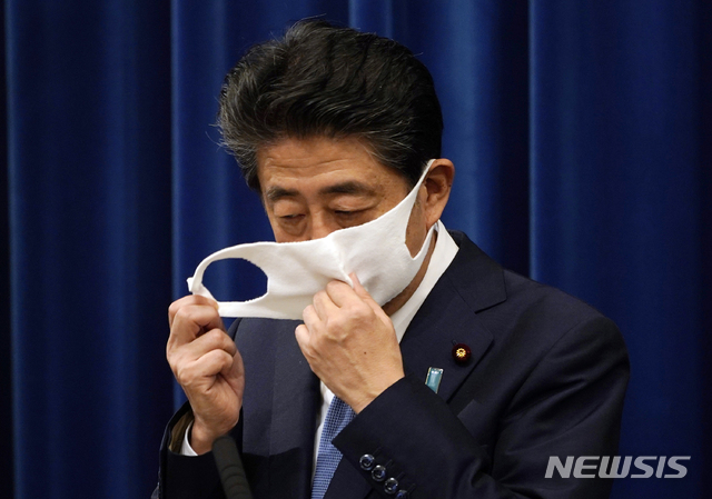[도쿄=AP/뉴시스]아베 신조 일본 총리가 28일 도쿄 총리공관에서 기자회견을 열고 발언에 앞서 마스크를 벗고 있다. 일본 최장수 총리인 아베 총리는 지병인 궤양성 대장염 재발이 8월 초 확인됐다면서&nbsp; 총리직을 사임한다고 정식으로 밝혔다. 2020.08.28.