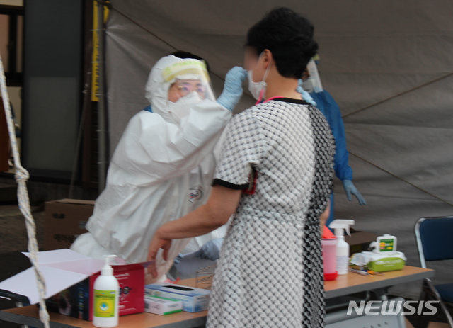 [제주=뉴시스] 양영전 기자 = 제주 신종 코로나바이러스 감염증(코로나19) 40번 확진자가 지난 24일부터 제주도청과 제주시청을 방문한 것으로 확인되면서 공직사회에도 비상이 걸렸다. 제주도는 30일 오후부터 확진자가 방문한 관련 부서 공무원들을 대상으로 코로나19 검사를 진행하고 있다. 사진은 이날 제주보건소에 마련된 선별진료소에서 검체를 채취하는 제주시청 공무원들의 모습. 2020.08.30. 0jeoni@newsis.com
