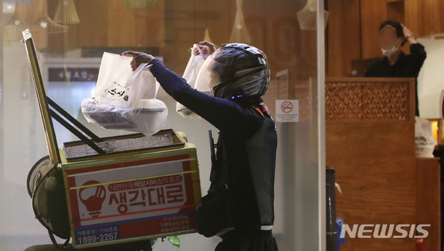 [서울=뉴시스] 박미소 기자 = 서울 송파구의 한 음식점 앞에서 한 배달기사가 포장 음식을 나르고 있다. 2020.08.30. misocamera@newsis.com