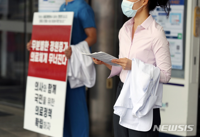 [서울=뉴시스] 고승민 기자 = 서울대병원이 외래진료를 축소하고, 전공의 등에 이어 교수도 집단 휴진에 나서는 것으로 알려진 31일 서울대병원에서 전공의가 피켓시위 및 유인물 배포를 하고 있다. 2020.08.31.kkssmm99@newsis.com