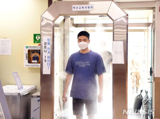 [서울=뉴시스]31일 해군교육사령부에서 실시한 '669기 해군병 입영' 중 669기 해군병 입영대상자가 전신소독기로 전신을 소독하고 있다. (사진=해군교육사령부 제공) 2020.08.31. photo@newsis.com