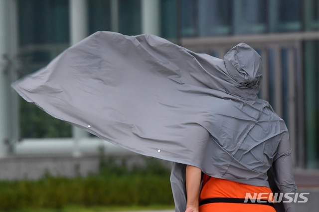 [부산=뉴시스] 하경민 기자 = 제9호 태풍 '마이삭'(MAYSAK)의 영향으로 부산지역에 태풍주의보가 발효된 2일 해운대해수욕장 인근 엘시티 앞을 지나던 한 시민의 외투가 강풍에 날리고 있다. 2020.09.02.&nbsp; yulnetphoto@newsis.com