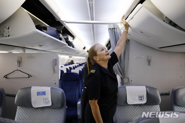 [ 텔아비브( 이스라엘)= AP/뉴시스]이스라엘 항공사 엘알(El Al)의 여승무원 헤드바 오파토프스키가 텔아비브의 벤구리온 국제공항에 착륙한 뒤 기내 짐칸들을 닫고 있다. 이스라엘정부는코로나19로 타격을 입은 국내항공사들에 현금지원을 하는 방안을 17일(현지시간)발표했다. 