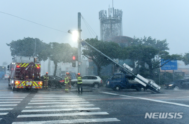 [제주=뉴시스]박진희 기자 = 2일 오후 제주시 공항 인근 도로에 제9호 태풍 '마이삭(MAYSAK)'의 영향으로 신호등이 부러져 소방구조대가 안전 조치를 하고 있다. (사진=박정근 사진작가 제공) 2020.09.02. photo@newsis.com