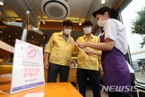 [서울=뉴시스] 지난달 30일 강북구 점검반이 프랜차이즈 커피전문점을 방문해 방역수칙 안내문을 설명하고 있다. (사진=강북구 제공) 2020.09.03.photo@newsis.com 