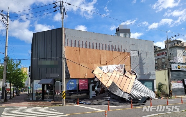 [울산=뉴시스] 구미현 기자 = 태풍 '마이삭'이 지나간 3일 오전 9시께 울산시 남구 삼산동의 한 상가 외벽 단열재가 파손돼 길가 전신주에 걸쳐져 있다. (사진=독자 제공). 2020.09.03. photo@newsis.com 