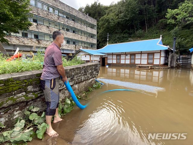 [양양=뉴시스] 김경목 기자 = 제9호 태풍 '마이삭(MAYSAK)'의 영향으로 강원 양양군에 322.5㎜의 많은 비가 내려 피해가 속출한 가운데 3일 오전 양양군 양양읍 거마리에서 주민이 집 마당에 가득찬 빗물을 빼내려고 안간힘을 쓰고 있다. (사진=양양군청 제공) 2020.09.03. photo＠newsis.com 