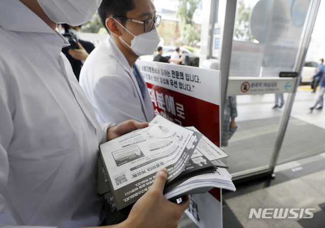 [서울=뉴시스] 고승민 기자 = 더불어민주당과 대한의사협회가 코로나19 안정화까지 의대정원 및 공공의대 확대 논의를 전면 중단하고 의료계도 집단휴진을 마치는 데 최종 합의한 4일 서울대병원에서 합의 소식이 타진되자 피켓시위를 하던 전공의들이 병원으로 돌아가고 있다. 2020.09.04.kkssmm99@newsis.com