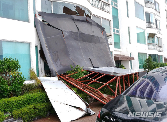 [부산=뉴시스] 태풍경보가 발효된 7일 오전 9시 50분께 부산 해운대구의 한 건물 옥상에 설치된 가로 7m, 세로 9m 크기의 철골구조물이 강풍에 20m 정도 날아가 인근 빌라 1~2층을 베란다를 덮쳤다. (사진=부산경찰청 제공)photo@newsis.com