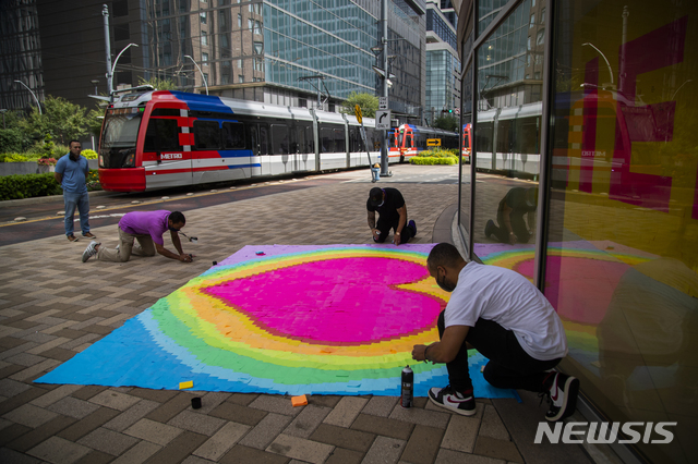 [휴스턴=AP/뉴시스]9일(현지시간) 미 텍사스주 휴스턴의 그린스트리트에서 지역 예술가 로버트 호지(가운데)와 데이비드 앤더슨 3세가 #StickTogetherHOU 라는 해시태그의 설치 작품 마무리 작업을 하고 있다. 이들은 각기 다른 색깔의 포스트잇 수천 장으로 만든 작품에 코로나19와의 싸움으로&nbsp; 숨진 필수 근로자들과 사회적 평등을 위해 싸운 사람들의 이름을 소개한다. 2020.09.10. 
