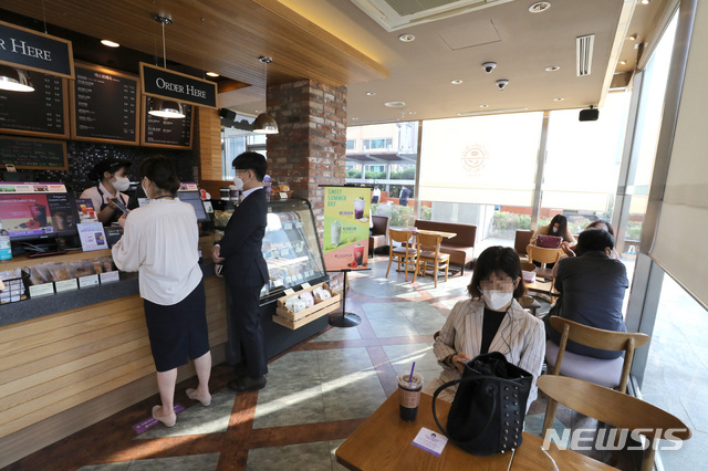 [서울=뉴시스] 전진환 기자 = 사회적 거리두기가 2주간 2단계로 완화된 14일 오전 서울 중구의 한 카페에서 시민들이 커피를 마시고 있다. 이번 조치로 밤 9시 이후 매장영업을 할 수 없었던 음식점과 영업시간 내내 매장 좌석을 이용할 수 없었던 프랜차이즈 카페를 정상적으로 이용할 수 있다. 2020.09.14.amin2@newsis.com