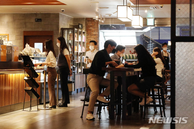 [서울=뉴시스]김병문 기자 = 사회적 거리두기가 2단계로 완화돼 수도권 지역 내 프랜차이즈형 커피전문점, 제과·제빵점 매장 안에서도 음료와 음식 섭취가 가능해진 14일 오전 서울 중구 스타벅스 한국프레스센터점을 찾은 시민들이 매장을 이용하고 있다. 2020.09.14.&nbsp; dadazon@newsis.com