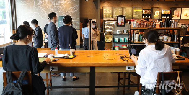 [서울=뉴시스] 전진환 기자 = 사회적 거리두기가 2주간 2단계로 완화된 14일 오후 서울 서초구의 한 프랜차이즈 카페에서 시민들이 커피를 마시고 있다. 이번 조치로 밤 9시 이후 매장영업을 할 수 없었던 음식점과 영업시간 내내 매장 좌석을 이용할 수 없었던 프랜차이즈 카페를 정상적으로 이용할 수 있다. 2020.09.14.amin2@newsis.com