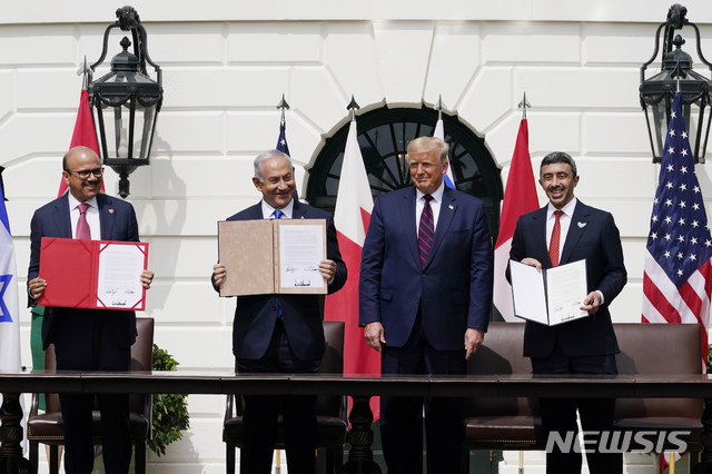 [워싱턴=AP/뉴시스]도널드 트럼프(오른쪽 세 번째) 미국 대통령이 15일(현지시간) 백악관 사우스론에서 이스라엘·UAE·바레인 정상과 '아브라함 협정'(Abraham Accords)에 서명 후 협정서를 들고 기념촬영을 하고 있다. 협정 명칭은 유대교, 이슬람교, 기독교의 공통 조상인 아브라함의 이름에서 따왔으며 트럼프 대통령은 증인 자격으로 서명했다. 사진 왼쪽부터 압둘라티브 빈 라시드 알자야니 바레인 외무장관, 베냐민 네타냐후 이스라엘 총리, 셰이크 압둘라 빈 자예드 알나흐얀 UAE 외무장관. 2020.09.16. 