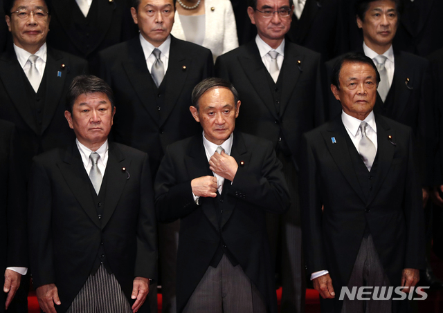 [도쿄=AP/뉴시스]지난 16일 스가 요시히데 일본 총리(앞줄 가운데)가 내각을 출범한 후 총리 관저에서 내각 각료들과 기념촬영에 임하기 전 넥타이를 만지고 있다. 2020.09.17.