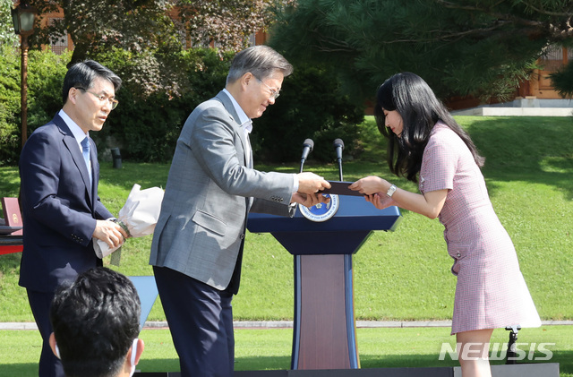[서울=뉴시스]박영태 기자 = 문재인 대통령이 19일 오전 청와대 녹지원에서 열린 제1회 청년의 날 기념식에서 조혜민 서울시 청년청 주무관에게 포상하고 있다. 2020.09.19.since1999@newsis.com