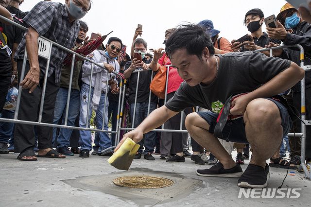 [방콕(태국)=AP/뉴시스]태국의 한 민주화 지지자가 20일 수도 방콕의 사남루앙 광장에 새로 설치된, "태국은 국민의 것"이라고 선언하는 명판을 닦고 있다. 태국 반정부 시위대는 이날 방콕 당국에 10개 항의 군주제 개혁 요구 리스트를 제출한 후 "승리"를 선언했다. 2020.9.20 