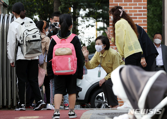 [서울=뉴시스]홍효식 기자 = 수도권 지역 학교들이 전면 원격수업을 끝내고 등교수업을 재개한 21일 오전 서울 강동구 한산초등학교를 방문한 유은혜 사회부총리 겸 교육부 장관이 등교하는 학생들과 인사를 나누고 있다. 2020.09.21.&nbsp; yesphoto@newsis.com
