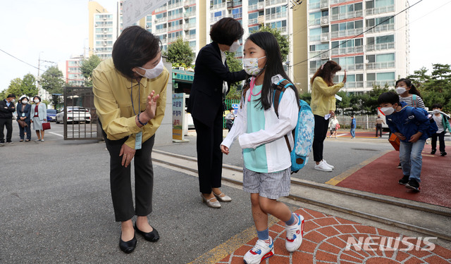 [서울=뉴시스]홍효식 기자 = 수도권 지역 학교들이 전면 원격수업을 끝내고 등교수업을 재개한 21일 오전 서울 강동구 한산초등학교를 방문한 유은혜 사회부총리 겸 교육부 장관이 등교하는 학생들과 인사를 나누고 있다. 2020.09.21. yesphoto@newsis.com
