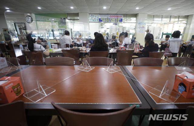 [서울=뉴시스] 고승민 기자 = 수도권 소재 유치원, 학교가 약3주간의 전면 원격수업을 마무리하고 등교를 재개한 21일 서울 화랑초등학교에서 가림막 좌석에 앉은 학생들이 거리두기 원칙을 지키며 점심식사를 하고 있다. 교육부에 따르면 21일부터 10월11일까지 수도권 유치원, 초등학교, 중학교는 3분의 1, 고등학교는 3분의 2 이내로 인원을 유지하고 등교한다. 수도권 코로나19 재확산으로 지난달 26일 전면 원격수업을 시작한 지 28일만이다. 2020.09.21.kkssmm99@newsis.com