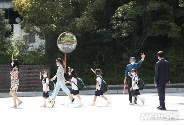 [서울=뉴시스] 고승민 기자 = 수도권 소재 유치원, 학교가 약3주간의 전면 원격수업을 마무리하고 등교를 재개한 21일 서울 화랑초등학교에서 학생들이 하교하고 있다. 교육부에 따르면 21일부터 10월11일까지 수도권 유치원, 초등학교, 중학교는 3분의 1, 고등학교는 3분의 2 이내로 인원을 유지하고 등교한다. 수도권 코로나19 재확산으로 지난달 26일 전면 원격수업을 시작한 지 28일만이다. 2020.09.21.kkssmm99@newsis.com