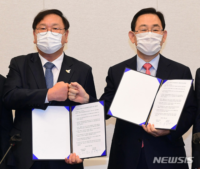 [서울=뉴시스]김선웅 기자 = 김태년 더불어민주당 원내대표와 주호영 국민의힘 원내대표가 22일 서울 여의도 국회에서 2020년도 제4차 추가경정예산안 합의사항 발표에서 합의문에 서명한 후 합의문을 들고 기념촬영을 하고 있다. (공동취재사진) 2020.09.22.&nbsp; photo@newsis.com