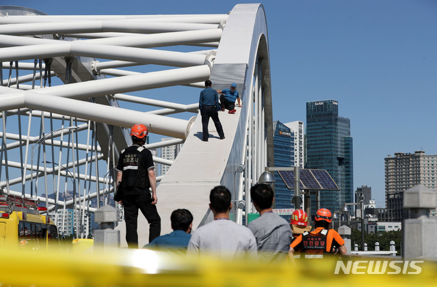 [서울=뉴시스]홍효식 기자 = 22일 오후 서울 영등포에서 마포로 넘어가는 양화대교 아치 형태 시설물 위에 50대로 추정되는 남성이 올라가 경찰 및 소방대원 등과 대치하고 있다. 2020.09.22. yesphoto@newsis.com
