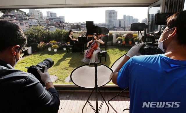 [서울=뉴시스]홍효식 기자 = '마포 M 클래식 축제' 영상팀들이 지난 22일 서울 마포구 라사라패션디자인학원 루프탑에서 마포 6경 클래식 홍대거리편 영상 촬영을 하고 있다. 마포 6경 홍대거리편은 첼리스트 임희영, 하피스트 피여나, 피아니스트 노예진이 참여한다. 2020.10.02. yesphoto@newsis.com