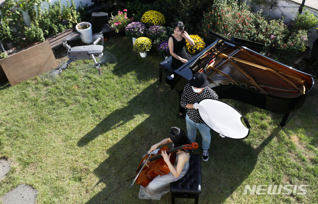 [서울=뉴시스]홍효식 기자 = '마포 M 클래식 축제' 영상팀들이 지난 22일 서울 마포구 라사라패션디자인학원 루프탑에서 마포 6경 클래식 홍대거리편 영상 촬영을 하고 있다. 마포 6경 홍대거리편은 첼리스트 임희영, 하피스트 피여나, 피아니스트 노예진이 참여한다. 2020.10.02. yesphoto@newsis.com