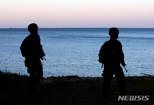 피격 해안이 보이는 연평도 해안[연평도=뉴시스] 최진석 기자 = 문재인 대통령이 군은 경계태세 강화 시지가 내려진 25일 오전 인천시 옹진군 연평도에서 해병대 장병들이 해안경계를 하고 있다. 장병들 위로 보이는 바다가 해양수산부 어업지도 공무원이 피격된 북한 황해남도 옹진군 등산곶 해안이다. 2020.09.25. myjs@newsis.com