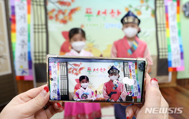 [인천=뉴시스] 이종철 기자 = 추석 연휴를 이틀 앞둔 28일 오전 인천시 부평구 한빛유치원에서 이번 추석 할머니를 보러가지 못하는 어린이가 한복을 입고 제주도에 있는 할머니와 강원도 홍천에 있는 할아버지께 영상통화를 하며 명절 인사를 하고 있다. 2020.09.28. jc4321@newsis.com