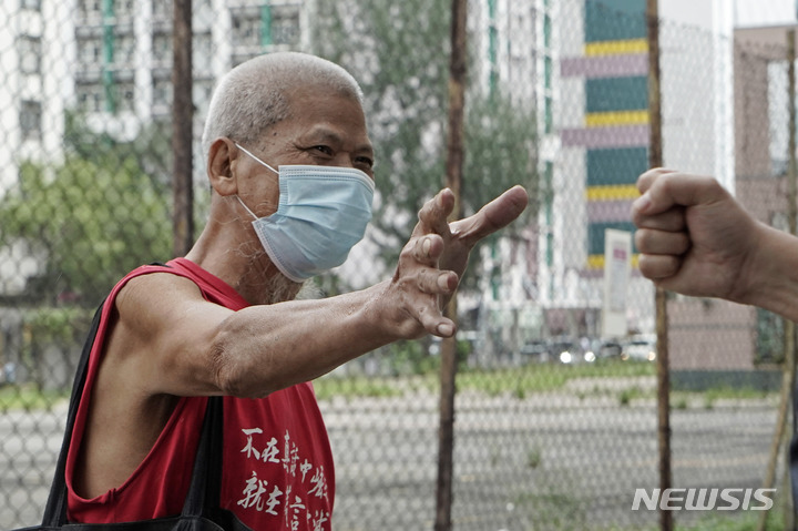 [홍콩=AP/뉴시스] 12일 홍콩 웨스트카우룽법원이 베이징동계올림픽 반대 시위를 계획했지만, 시행하지 못한 베테랑 활동가 쿠씨이우(古思堯·75)에게 징역 9개월형을 선고했다. 지난 2020년 9월30일 법정에 도착한 쿠씨가 지지자들과 인사하는 모습. 2022.07.13